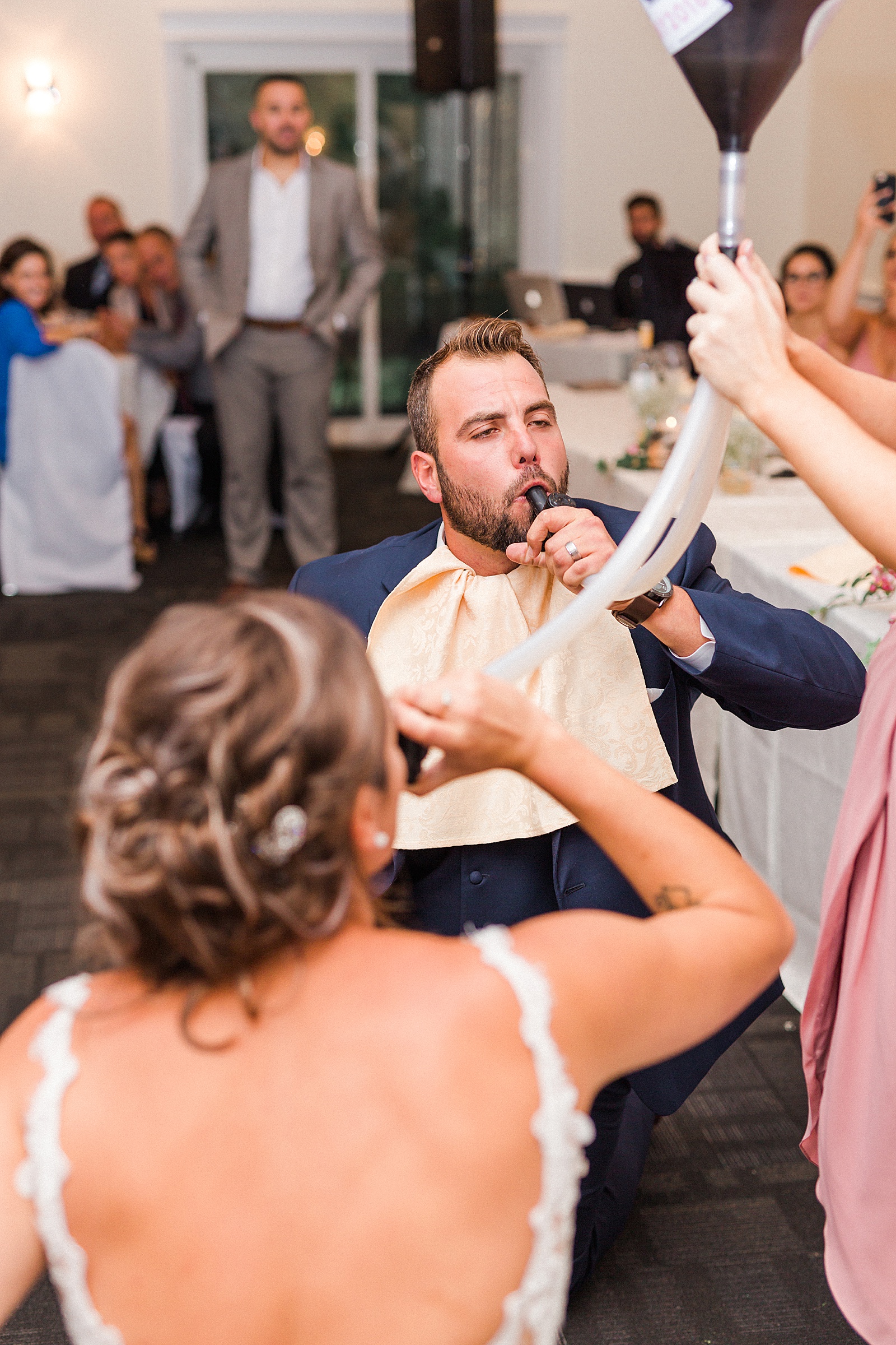 bride and groom chugging with a funnel